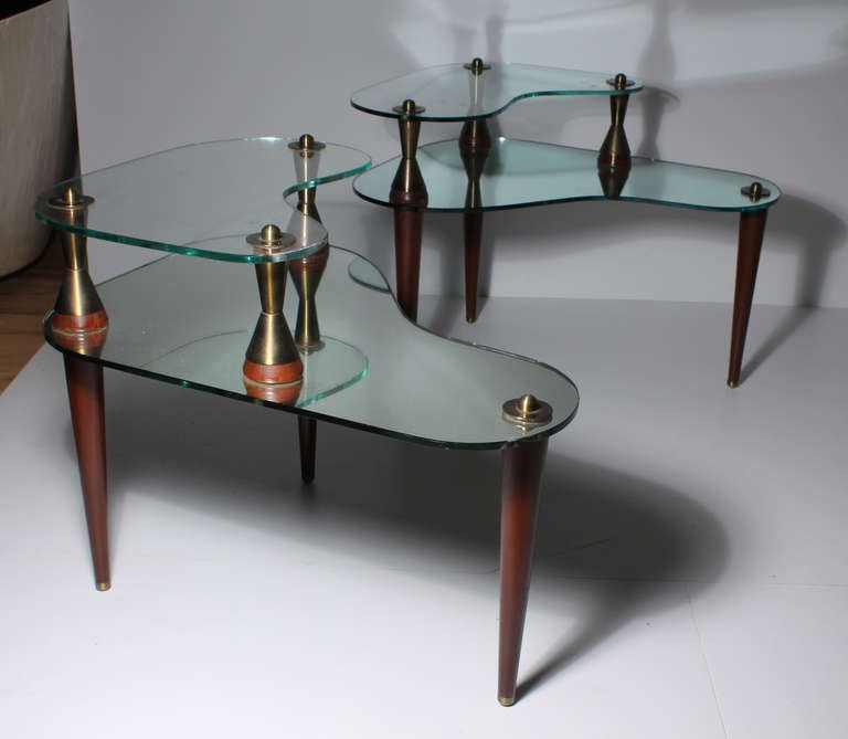 A vintage kidney shaped mirror and glass coffee table accompanied with a matching pair of end tables. Glass and Mirror have organic wavy forms suspended by conical legs with atomic form supports.

coffee table:
about 15.25