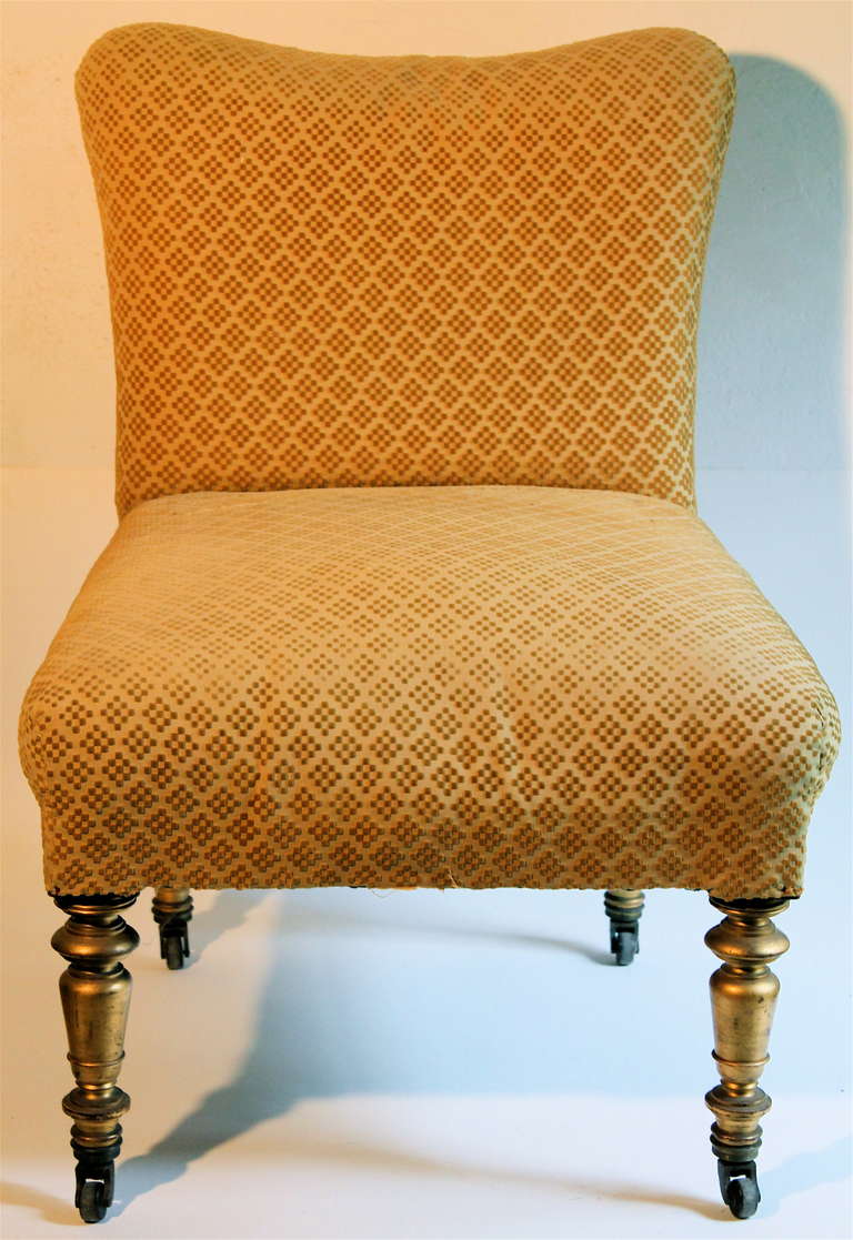 Old but not original upholstery. Lacks the bottom fringe.  Turned legs are gilded.  Numbers on two legs.  India Rubber Comb Co. Casters.  Similar chair shown in the Drawing Room of the William H. Vanderbilt House, illustrated in 'Artistic Houses',