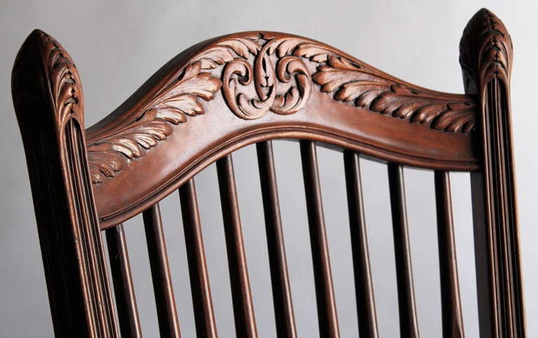 A large carved mahogany Rocking Chair fully developed with Beaux Arts Styling in the Tiffany- Davenport manner.