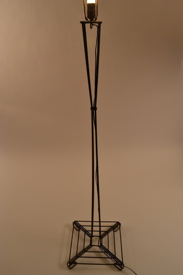 Interesting waisted form floor lamp constructed of bent iron rods. Black paint finish over iron rod frame, working, original condition, no shade included.