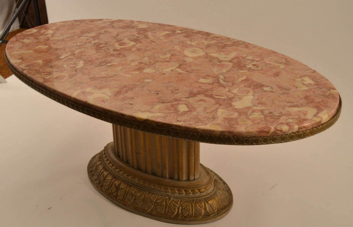Rouge marble top rests on a fluted column gold washed finished base. Classic Glam Art Deco form, great quality and design. Coffee, Cocktail table in  ready to use  original condition.