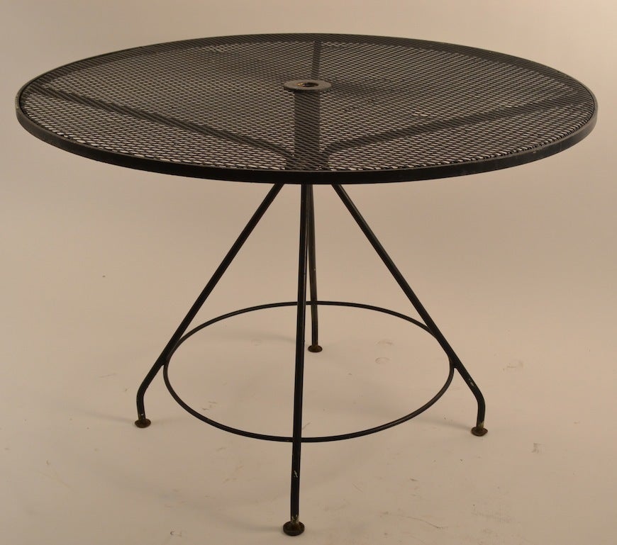 Metal mesh top pedestal base outdoor dining, cafe table. Comes with the original cast iron base for the shade umbrella, if you care to use one.