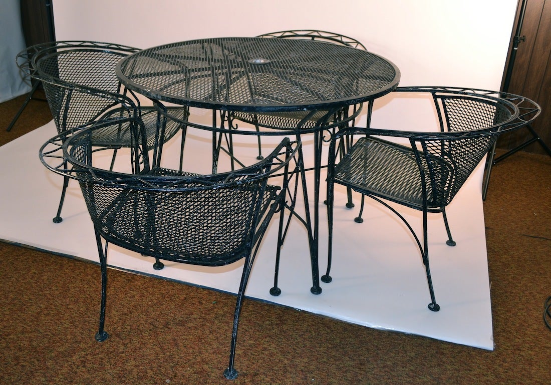 Wrought iron and mesh table and chairs, set includes four chairs, and the round table  ( original umbrella and stand can be included, however not pictured ) Dimensions in listing are for the table , chair dimensions as follows:
 Seat H 17