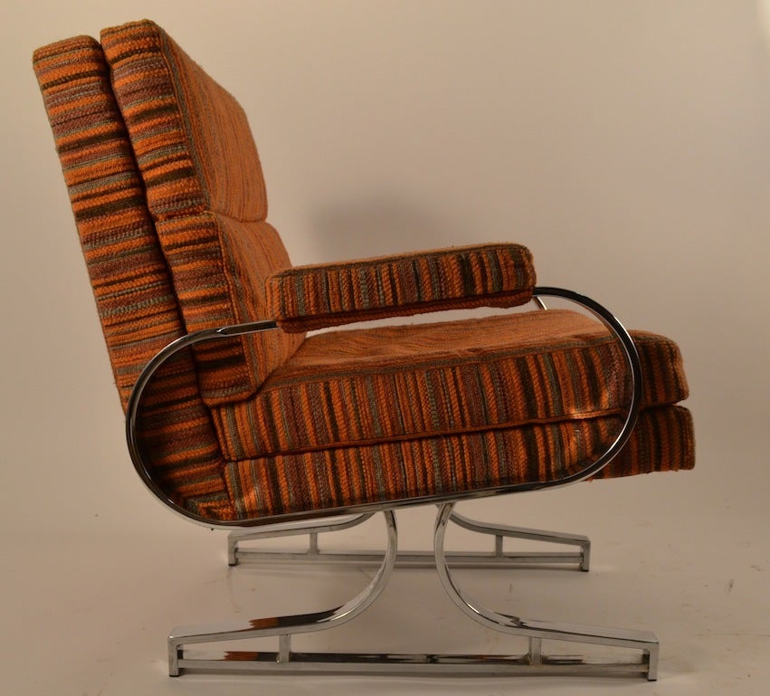 Chrome base and arms, upholstered seat, back and armrests. Original orange stripped fabric, lounge, club chair. We are also offering two full sized sofas from this same suite, if you are looking for a large seating group.