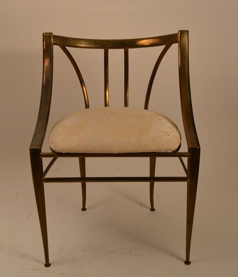 Unusual form brass frame chair, with upholstered seat. The finish shows signs of age, but can be polished to high shine if you prefer as the frame is solid brass. Upholstery is serviceable however you may want to recover to taste.  More modern in