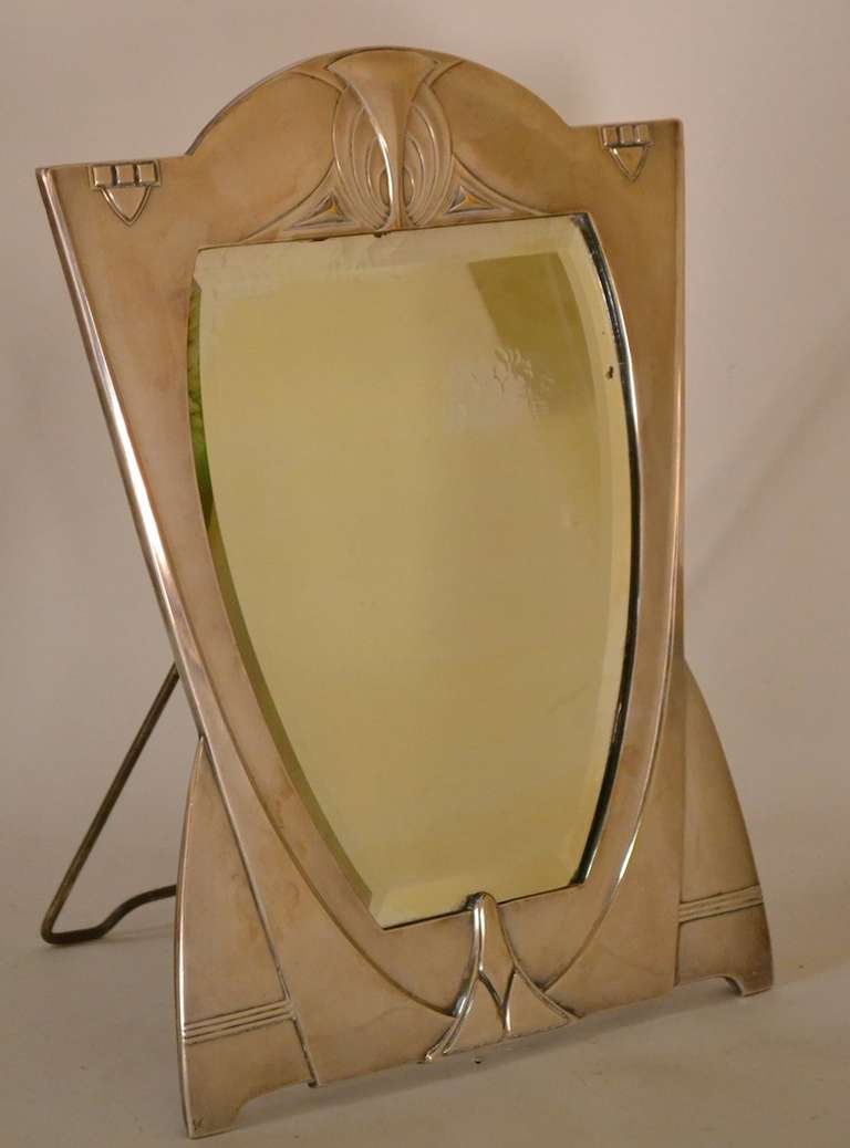 Jugendstil Secessionist make up mirror - elegant silver plate bevelled plate glass shield form mirror. Some minor alligatoring to the mirror silvering, normal and consistent with age, missing one ball form nut on the back.