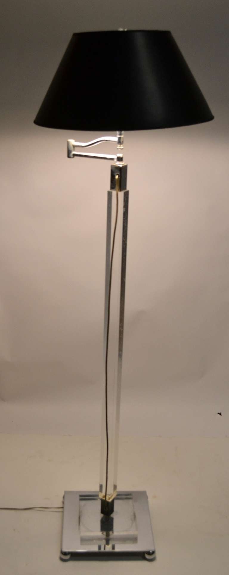 Art Deco period swing arm chrome and lucite floor lamp. Squared vertical standard, chrome ball feet, base, and fitments. The adjustable top makes this a perfect reading lamp.