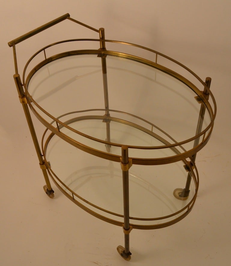 Two tier rolling cart, brass frame and glass shelves. Very good original condition,  ready to use stylish  Mid Century serving trolley cart. Probably Italian made, but undocumented.