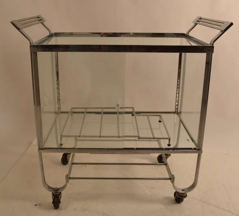 This cart was made by Treitel Gratz, top American metal shop Ca 1930's whose clients include legendary designers such as Deskey, Loewy, Noguchi, etc. Expected quality, and craftsmanship, this model is the harder to find version with the sliding