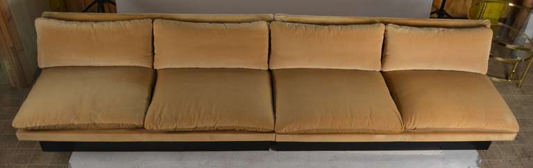 Low slug armless two piece sofa, in original cream color cotton velvet, some wear to fabric, usable as is or reupholster to taste.  Can be configured as one long sofa (120
