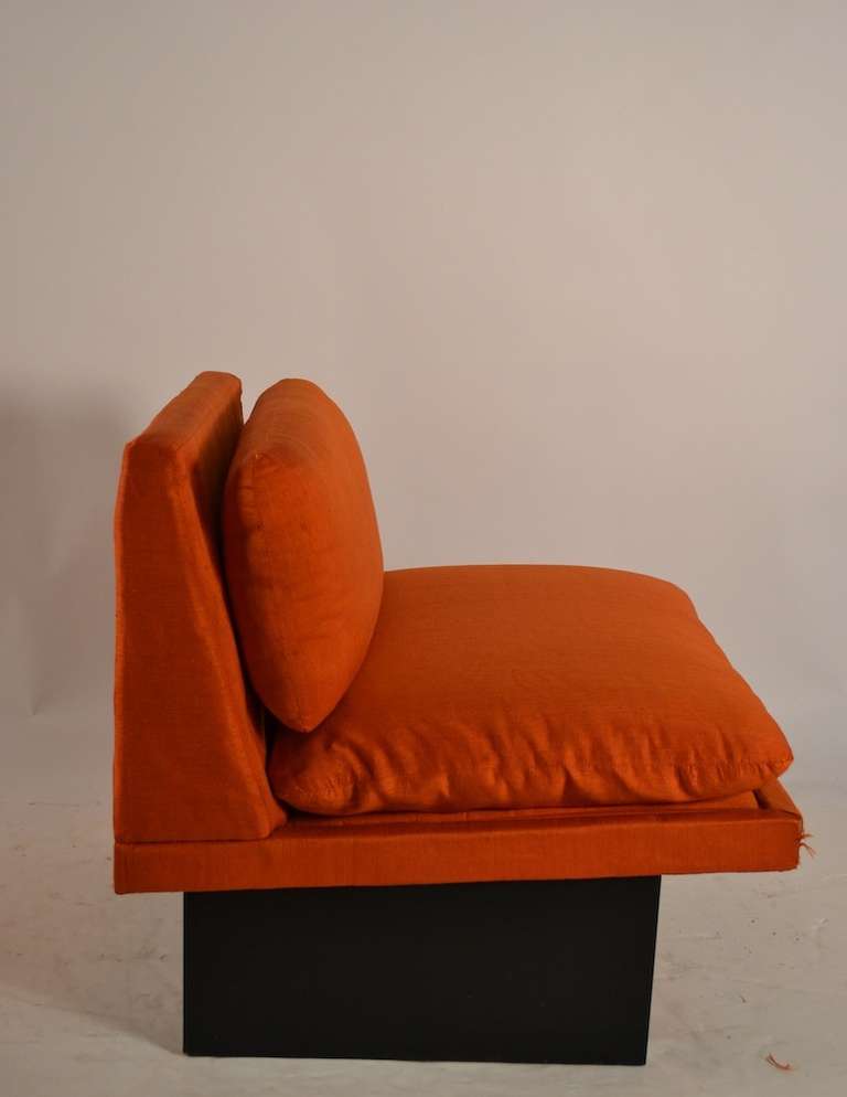 Original raw silk, orange upholstered armless chair. Wear to fabric, usable but worn. Groovy form, fun low slung chair.