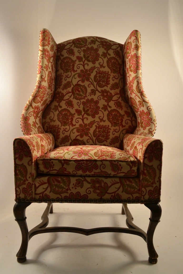 Very well made, decorative, and comfortable wing chair made by Louis Mittman. Nice brass stud nail head trim detail, some minor wear, to  ( original ) fabric, usable as is, or reupholster to taste.