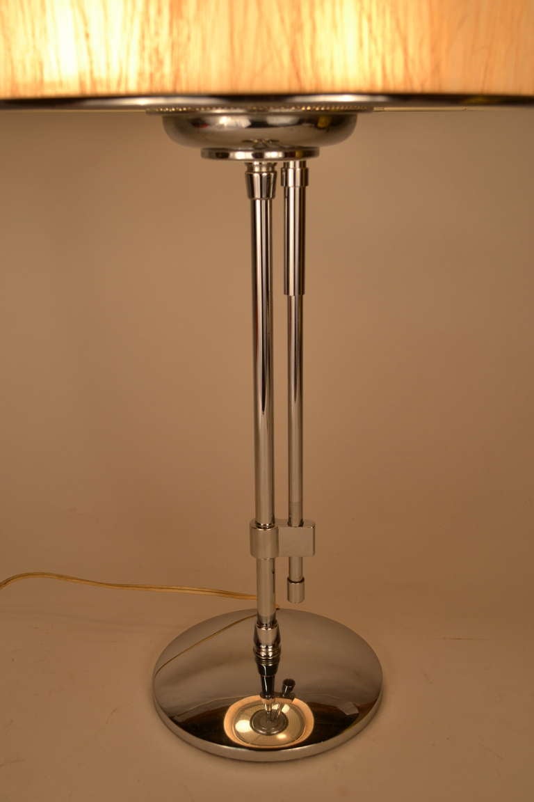 Attributed to Lighjtolier, this sleek and stylish lamp has an unusual three way on/off switch mechanism, operated by moving the shorter vertical tube up and down. Extra fine original condition, including original shade.