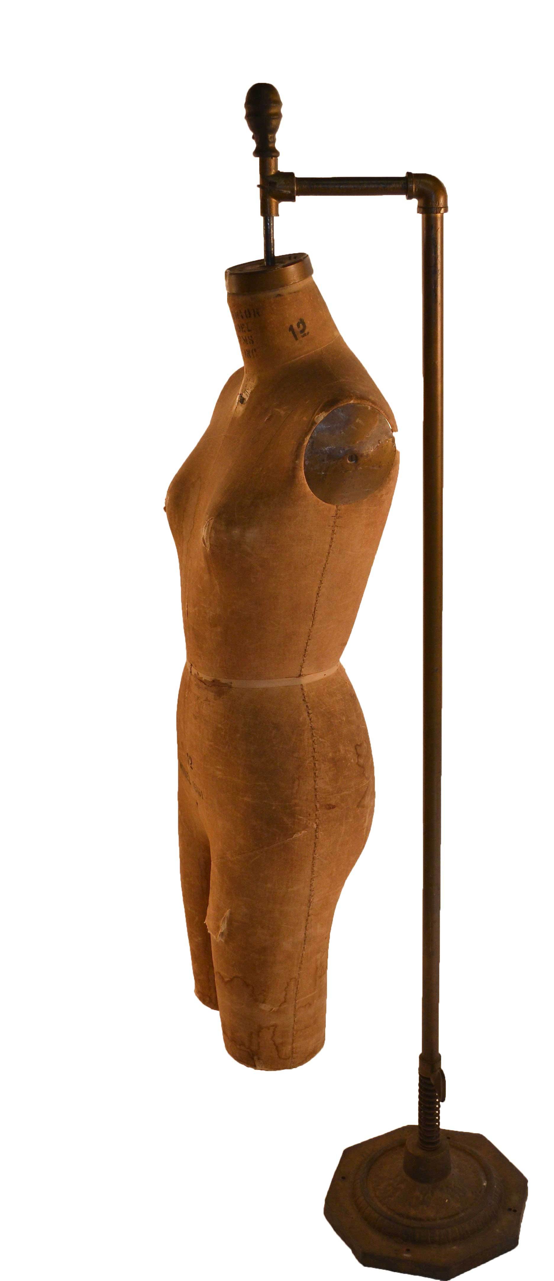 Antique dress makers form, canvass body with cast iron base stand. Small tear on the leg of the figure, visible stains to fabric, please see images. Marked 