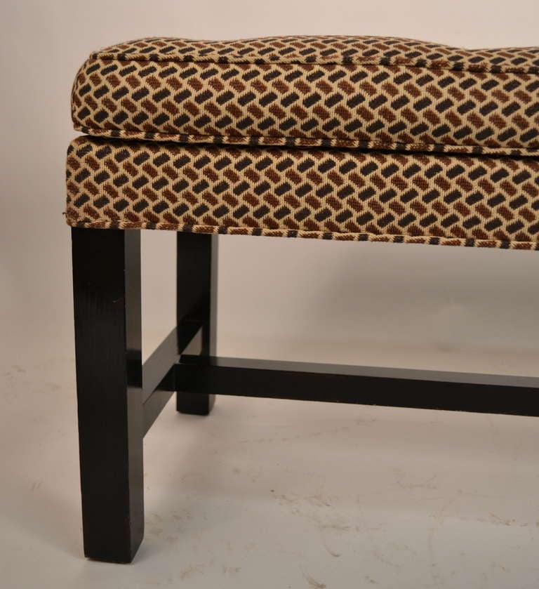 Long bench, tufted upholstered top, original fabric, legs in original black paint finish. 
