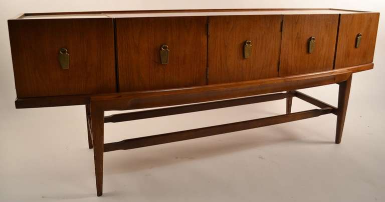Low slung elegant server, marble and walnut bow front, Mid Century Credenza. Five doors, one is stationary, four open to revel storage space. 
Some wear to finish, normal and consistent with age.