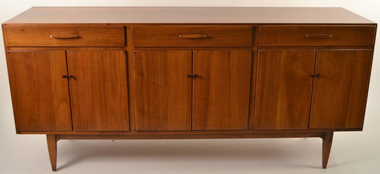 Classic Mid Century Danish Modern sideboard, American manufacture in the Danish School. Solid walnut with rosewood pulls, three drawers over six doors. Ample storage, clean original condition, great quality craftsmanship, and construction.