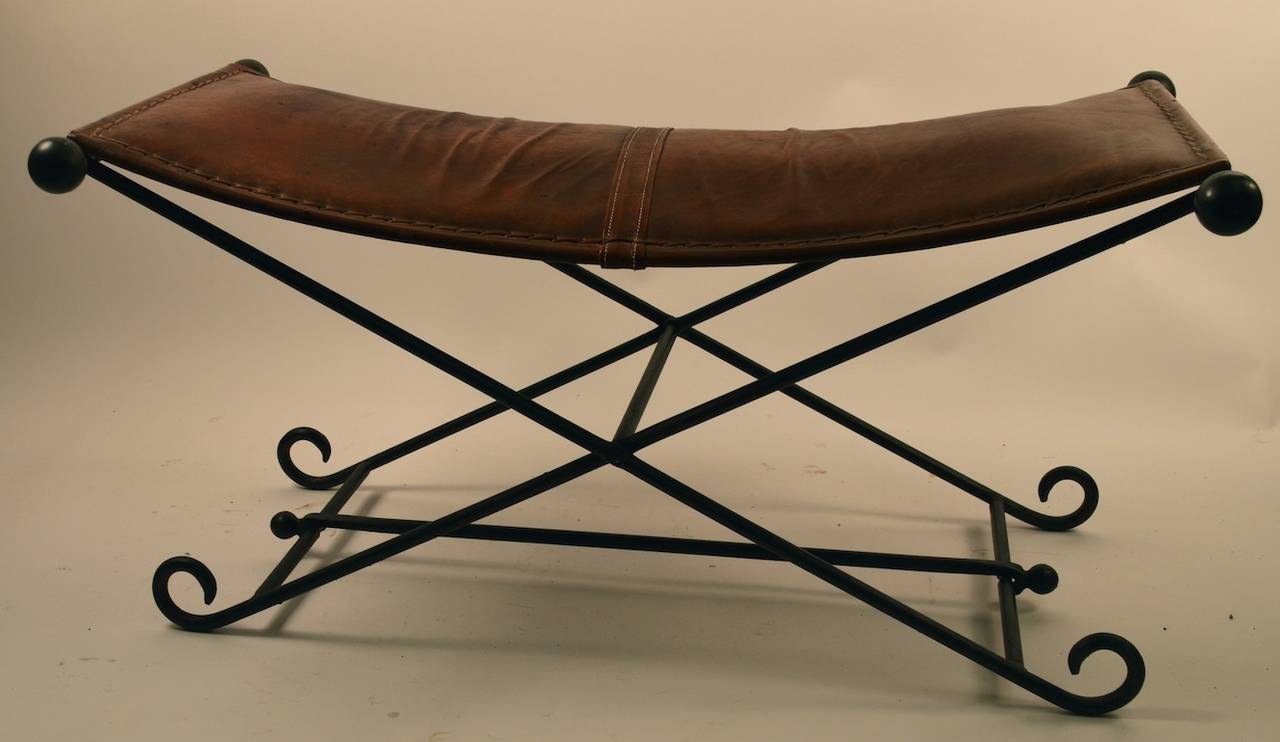 Wrought iron base with leather saddle seat top. The top is removable, and the base folds up for easy storage, and transportation. Wonderful distressed leather top, black iron rod base.
 Check the smaller companion bench we are also listing, if you