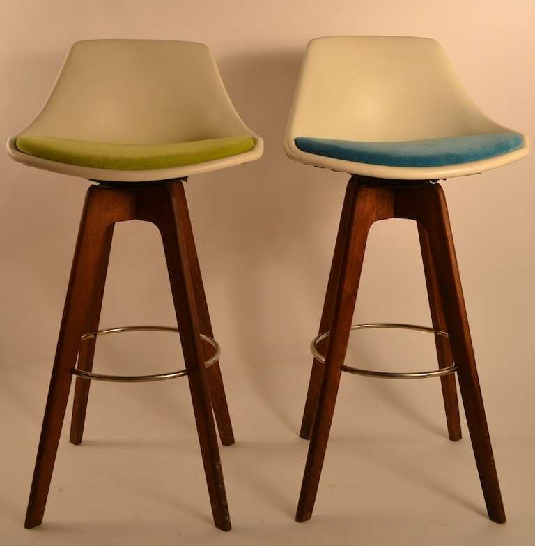 Mod style vinyl back, velvet  seats two in blue and  two chartreuse. Minor abrasions and wear to surfaces, but clean and ready to use.  Four swivel bar, counter height stools, upholstered seats, on sculptural wood legs with metal foot rest.