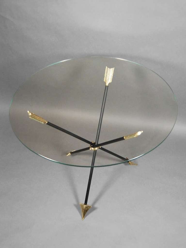 Tripod occasional table in the Neoclassical style, and comprised of three intersecting steel and brass arrows with 1/4 inch glass top.