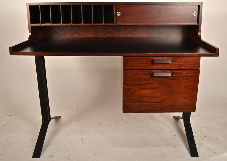 Mid Century Modern Architectural desk, Rosewood case, black laminate writing surface, cast iron legs. This interesting desk originally came from an Architects office, in NYC furnished in the 1950's. 
The desk features a pigeon hole gallery, with