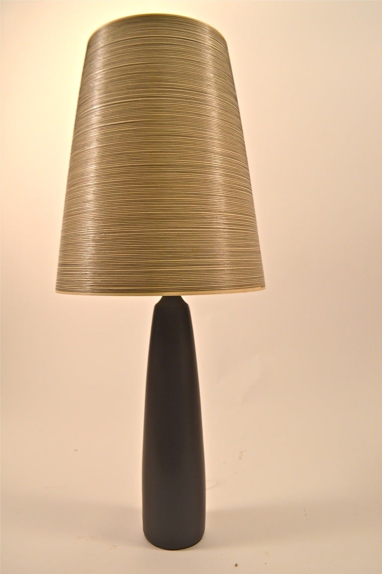 Ceramic lamp designed by Lotte and Gunnar Bostlund. Brown ceramic finish, original shade, and finial. Fine, working condition, impressive scale Mid Century Modern table lamp.