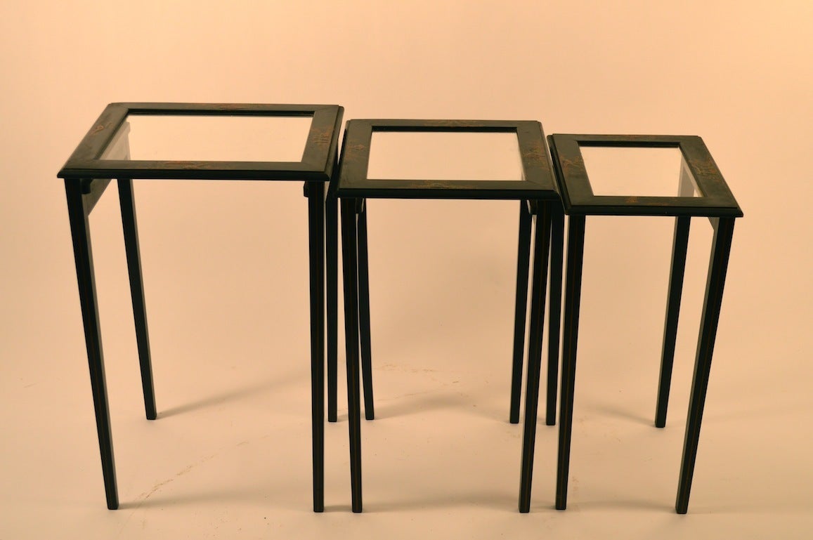 Diminutive nest of three tables, black ground, with paint decorated 