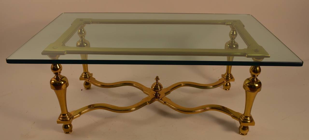 Elegant and sophisticated, well made and executed.This table has  substantial brass base in the Colonial Style, but Modern in interpretation, and a thick (.75