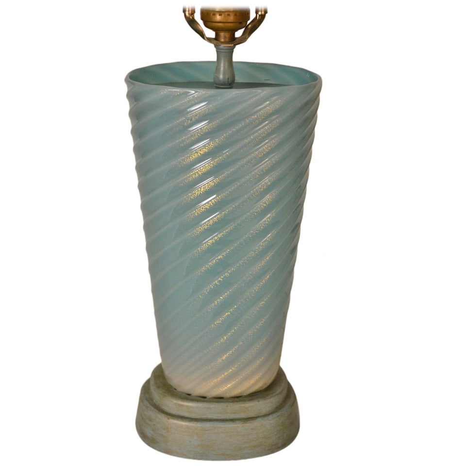 Elegant Hollywood Regency turquoise glass with gold flake inclusion. Original painted stepped wood base. Probably Barbini, or Fratelli Toso, or possibly Seguso,  unsigned. 
 Shade not included.
Height to top of glass - 11.5