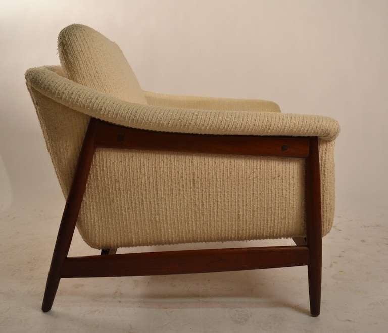 Pr. of club chairs by DUX - teak frames with original with off white fabric. The fabric ( cotton ) is usable but would benefit from a steam cleaning.
