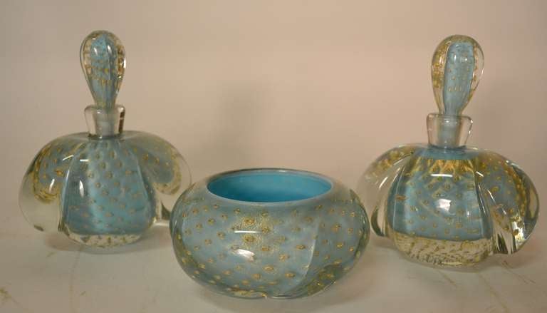 Two large perfume, cologne bottles, and matching bowl. No damage, controlled bubble, gold inclusion and sommerso technique. Fine Art Glass from Murano, from the Venetian School.
Dimensions in listing are for the bottles, not the bowl.