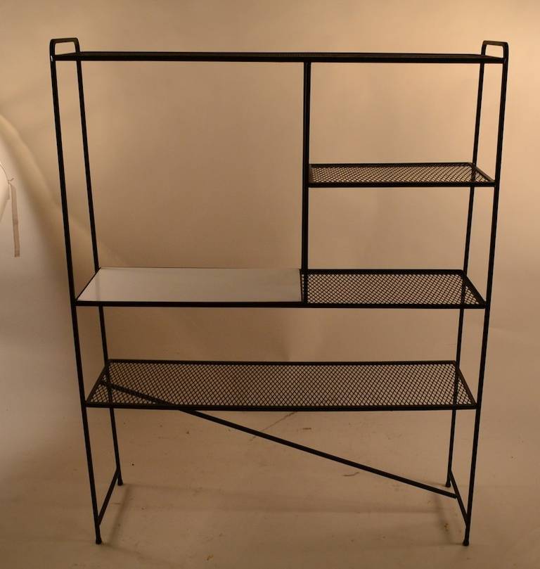 Black painted metal (original finish) with a white laminate shelf. Perfect for stereo and or flat screen, display storage unit. Designed by renown designer Freda Diamond, also is reminiscent of Weinberg, or Umanoff. Mid-Century Modern period item