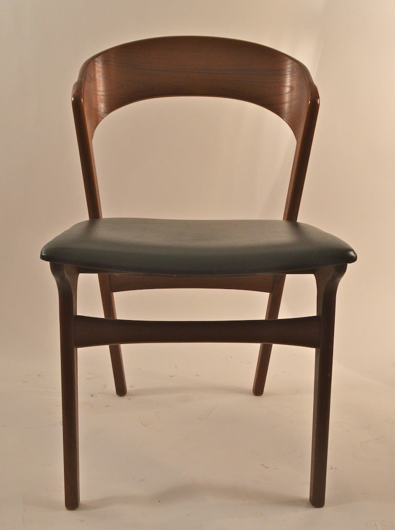 Four teak dining chairs, marked 