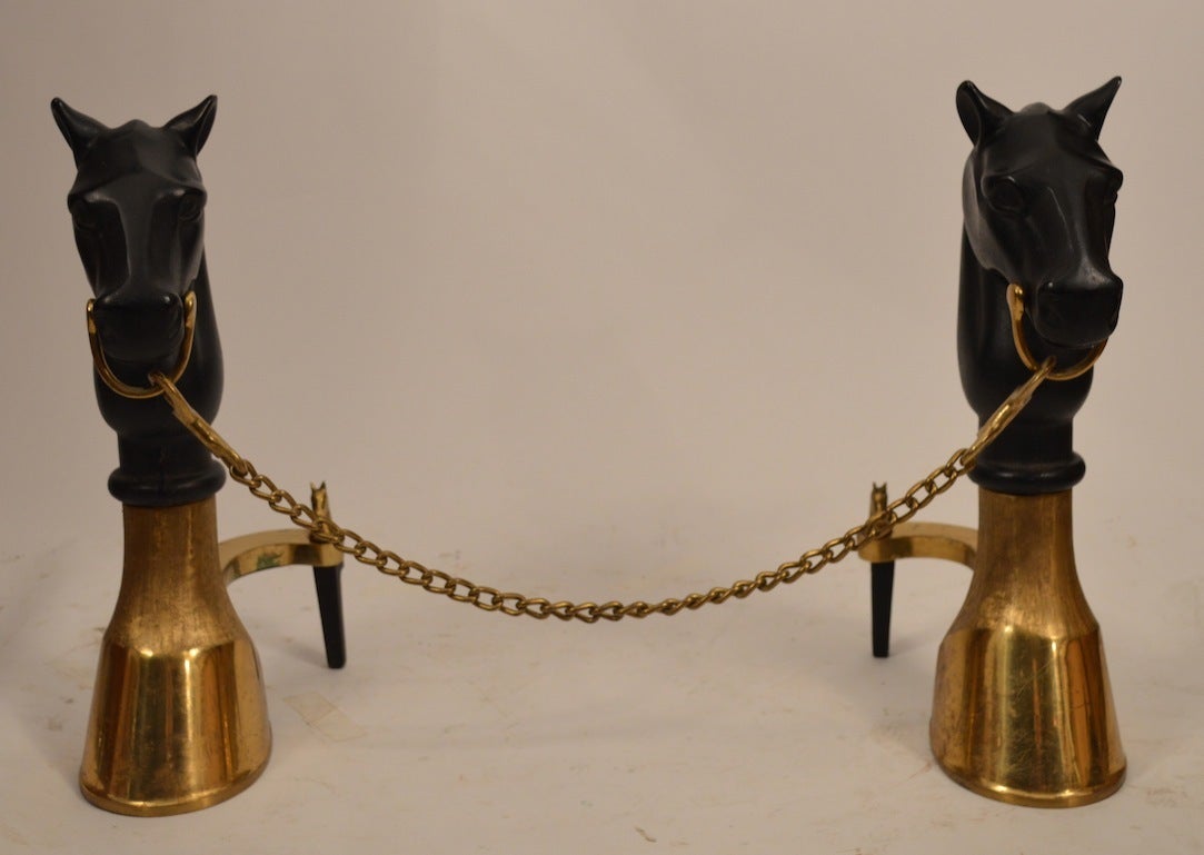 Brass hoof bases with black iron horse head tops, and bit chain that joins the two. Stylish, chic equestrian theme fireplace equipment.