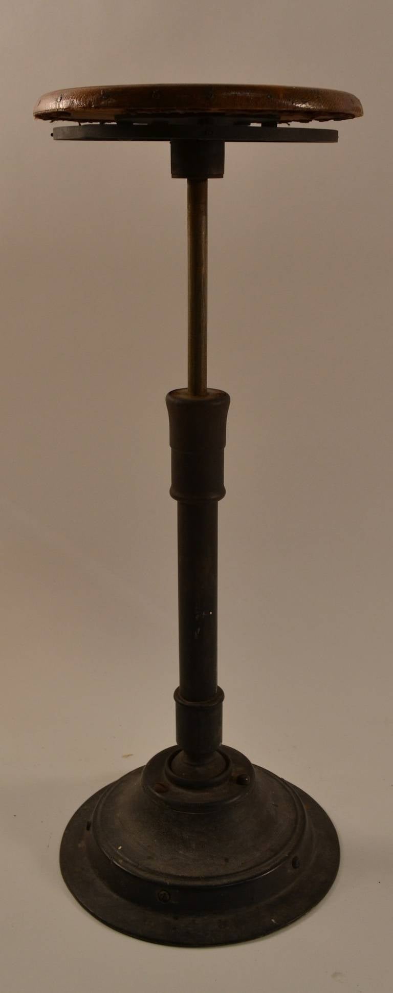 Wood seat, cast iron base, stool swivels, tilts on a ball joint, and will adjust in height (highest position 29.5