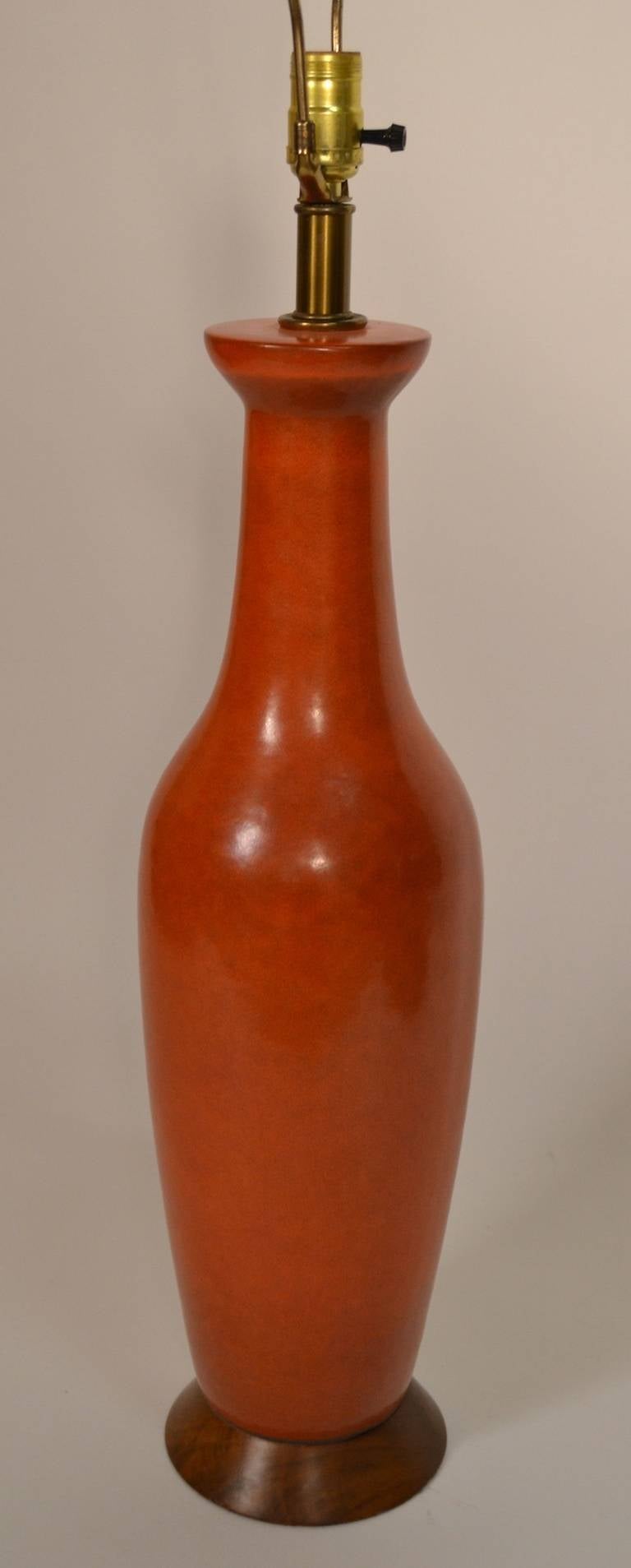 Simple bold form, solid Chinese style orange glaze, mounted on original walnut base. Height dimension in listing includes harp, height top top of orange ceramic is 24.75