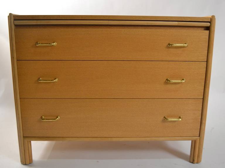 Interesting form chest by McGuire of San Francisco, three drawers beneath a pull out work surface. Bleached oak finish, with Faux bamboo brass pulls.