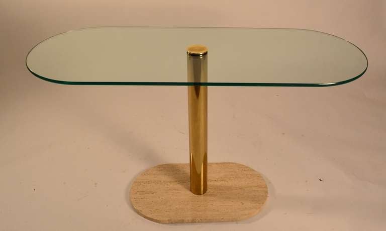 Thick glass top rests on a brass tube, which is anchored by an oval travertine marble base ( marked Italy ). Perfect form for a foyer, hallway, sofa table,  or other occasional use.