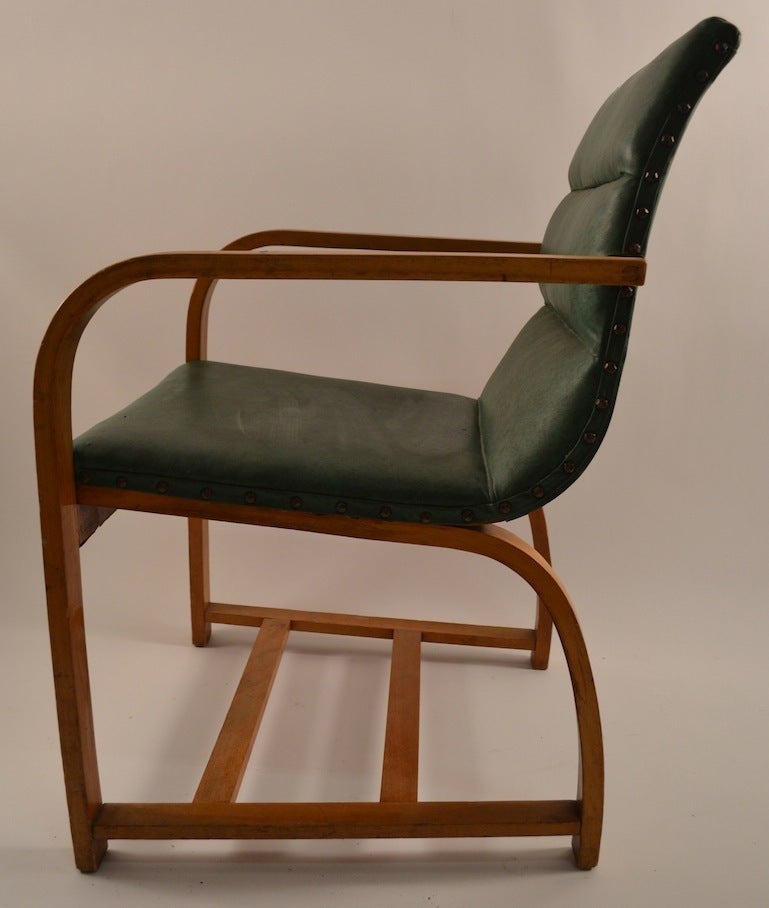 Classic Gilbert Rohde design, steam bent wood frame, original vinyl upholstery, slight tear on the back, as shown. Elegant Machine Age, American Art Deco iconic chair.