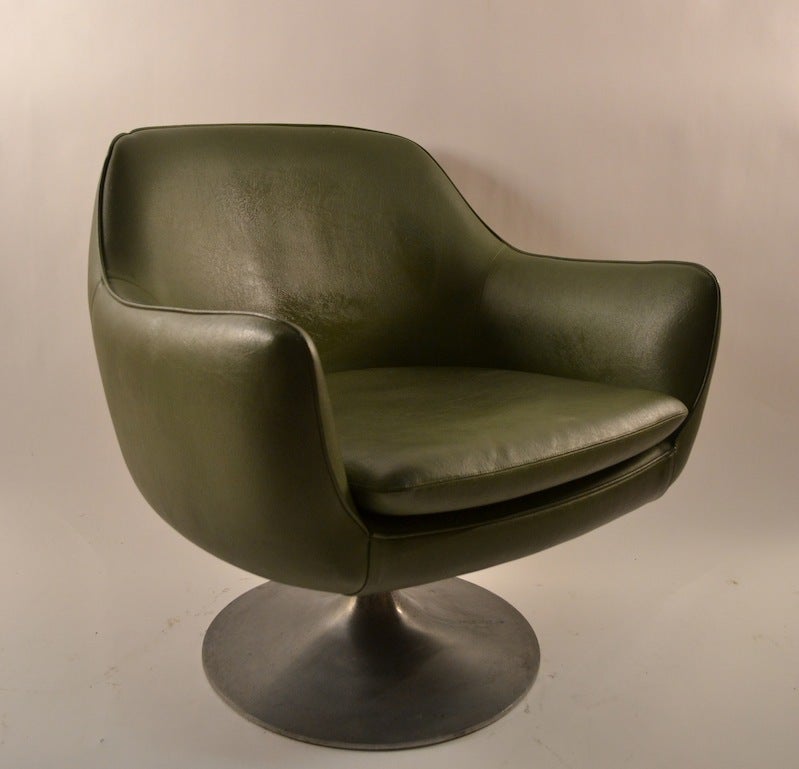Mod style swivel pod chair in green vinyl, on cast aluminum pedestal  base. Old repair on the vinyl at the hand rest corner, pictured in listing.