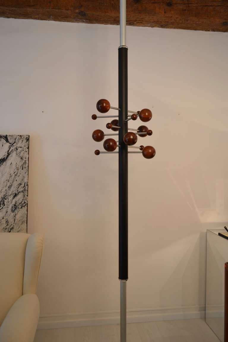 Chic Osvaldo Borsani adjustable coat rack model no. AT16.
Matt chrome-plated tubular metal, leather-covered metal, walnut, painted tubular metal.

Manufactured by Tecno, Italy. Bottom end with paper label ‘Tecno/MILANO’.
284.8 cm. (112 1/8 in.)