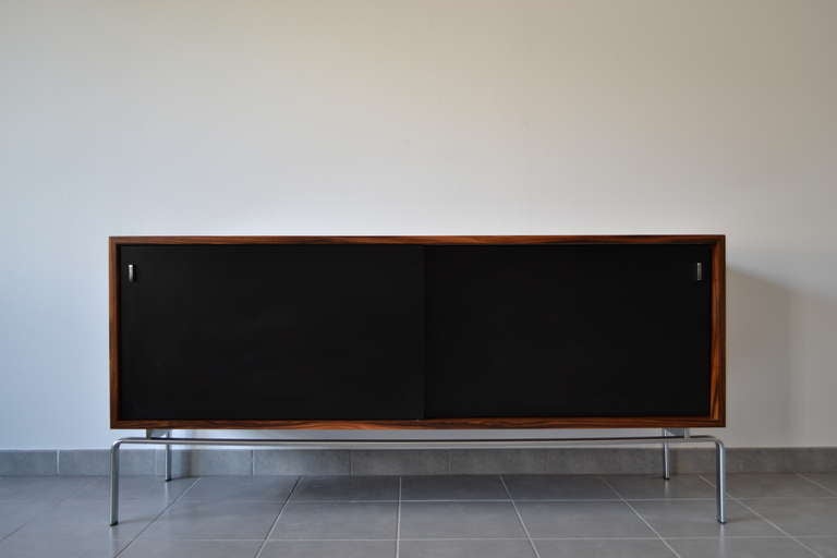 Preben Fabricius & Jørgen Kastholm FK 150 sideboard in Santos rosewood on Mat Chrome structure. Front with two black-lacquered sliding doors with steel handles enclosing shelves. 

This sideboard is a perfect room divider as it is veneered on all