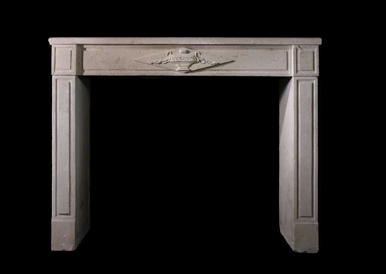 A caen limestone 19th century French mantel with a carved urn across the frieze in the Louis XVI style with en trumeau. Opening dimensions: 45