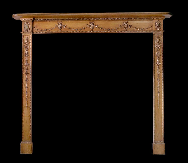 18th century pine and gesso mantel with swags and ties across the frieze. The jambs have bell drops topped with a pineapple below a rosette on the capital block. Opening dimensions: 48