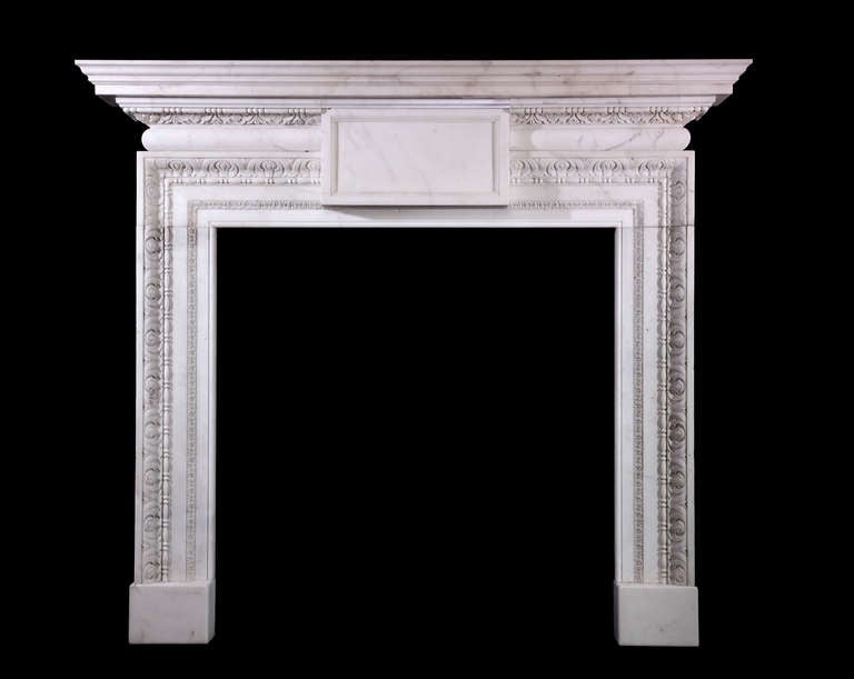A pair of mid-18th century English mantels of architectural form in veined Italian statuary marble featuring a barrel frieze with projecting plain center tablet and carved inground mouldings on plain block feet, circa 1750 with later additions.