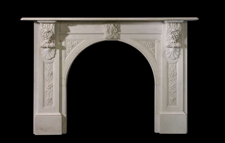 A fine statuary marble Victorian arch mantel circa 1845 with strong floral carving on the corbel, in the spandrels, on the keystone and down the jambs. Opening dimensions: 37