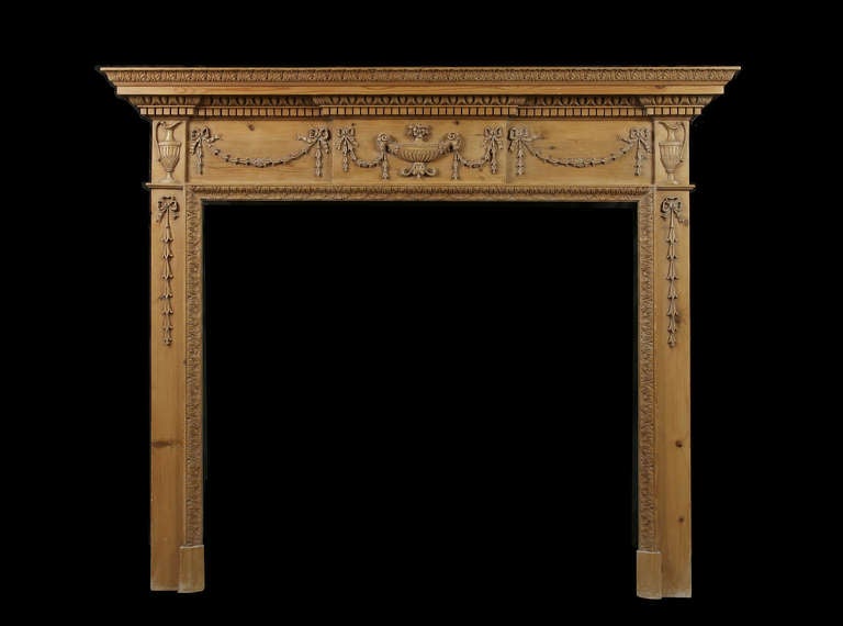 19th century carved pine Georgian style mantel carved with urns and tied swags. Opening Dimensions: 45