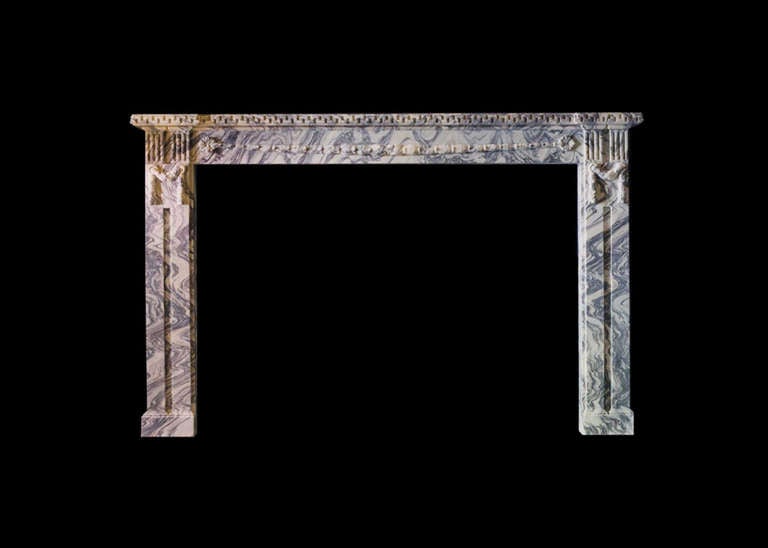 An impressive marble mantel in the Empire style in opera fantastico breche marble with carved frieze and pilasters and mantel shelf with leading edge carved with Greek key detail. Opening dimensions: 71.13