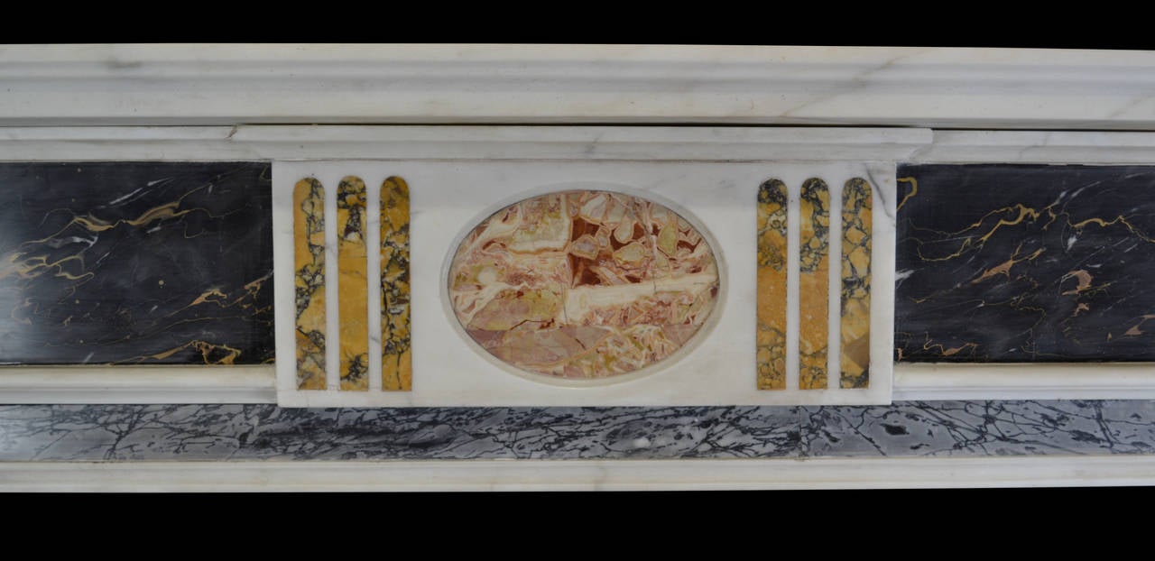 A striking early 19th century mantel in a visually dramatic combination of marbles. The statuary pilasters headed by Acanthus corbels and flanked by Grey Bardiglio ingrounds and outgrounds. The projecting central frieze tablet inlaid with an oval of