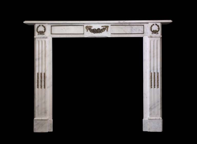 Statuary marble early 19th century mantel in the Louis XVI style with decorative brass ormolu mounts. Opening Dimensions: 33